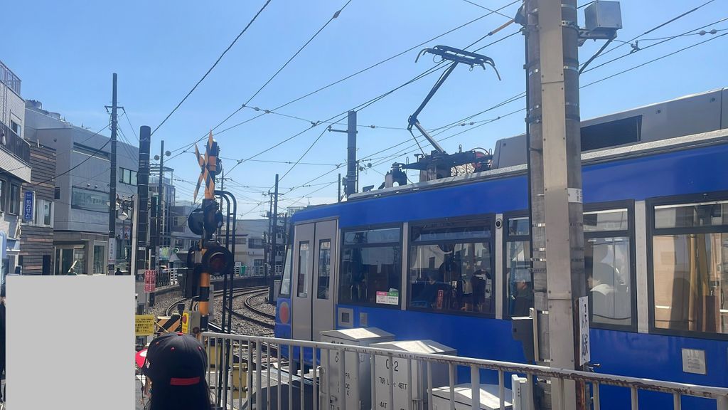 下高井戸駅前にある世田谷線踏切と世田谷線車両